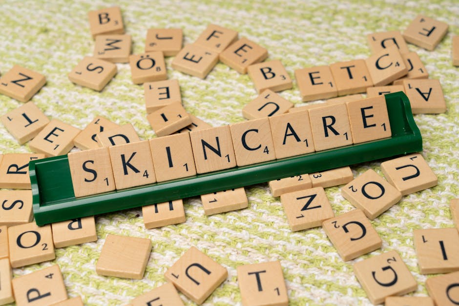 Scrabble tiles spelling 'skincare' on a green textured surface, representing beauty and wellness